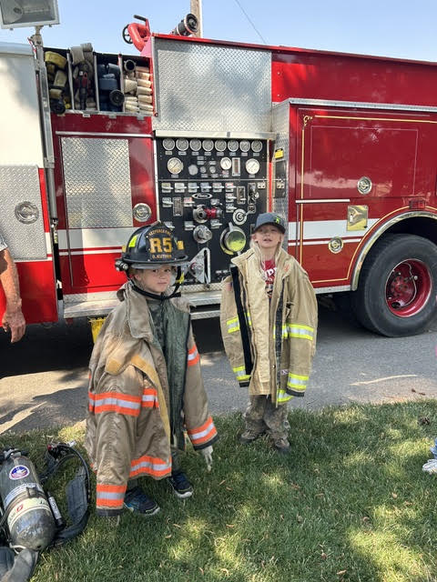 Attendees at the library's end-of-summer reading party dressed up in firefighter coats and helmets. 
