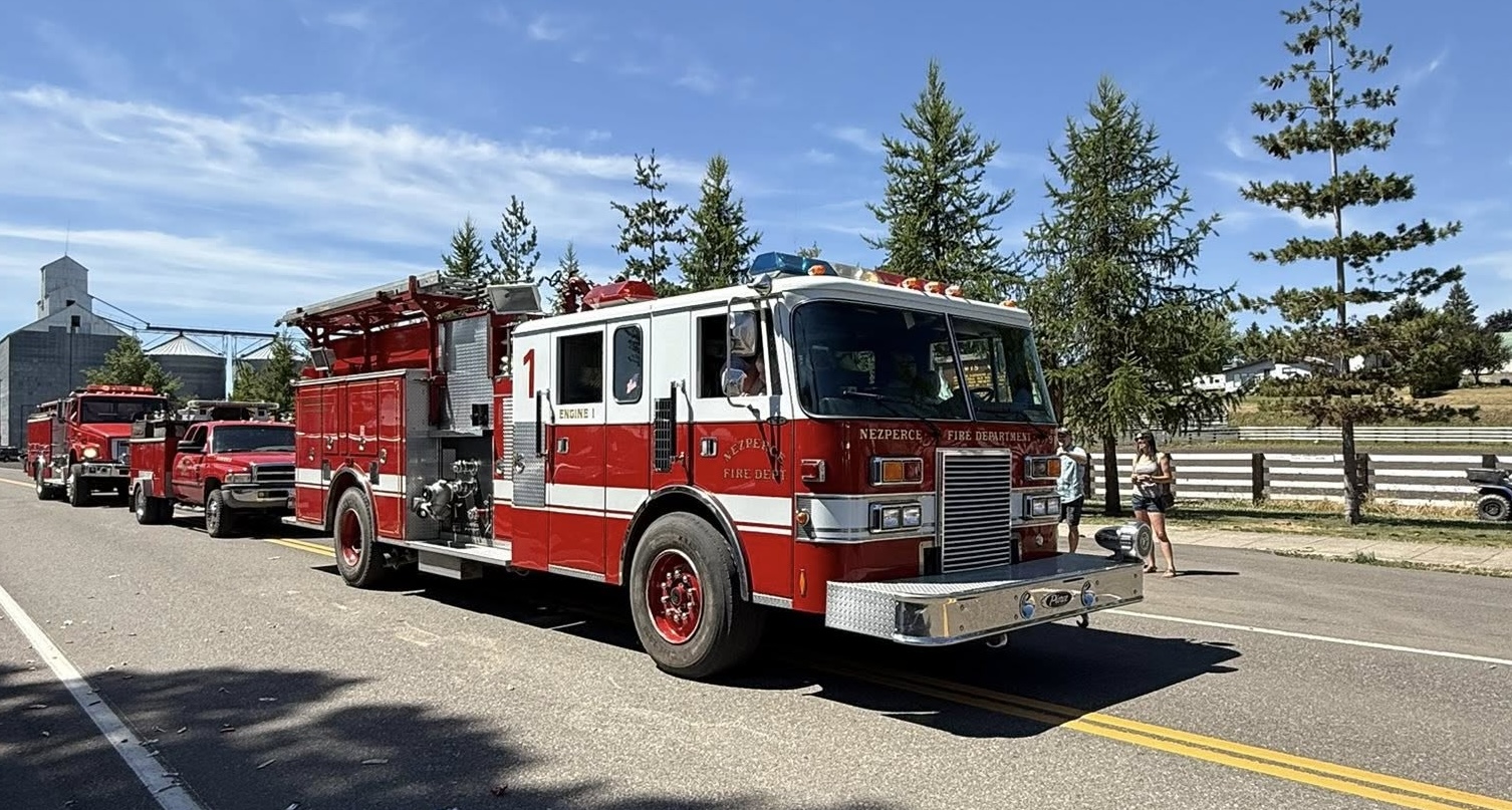 Fire engines and pickups drive down Oak Street in Nezperce. 
