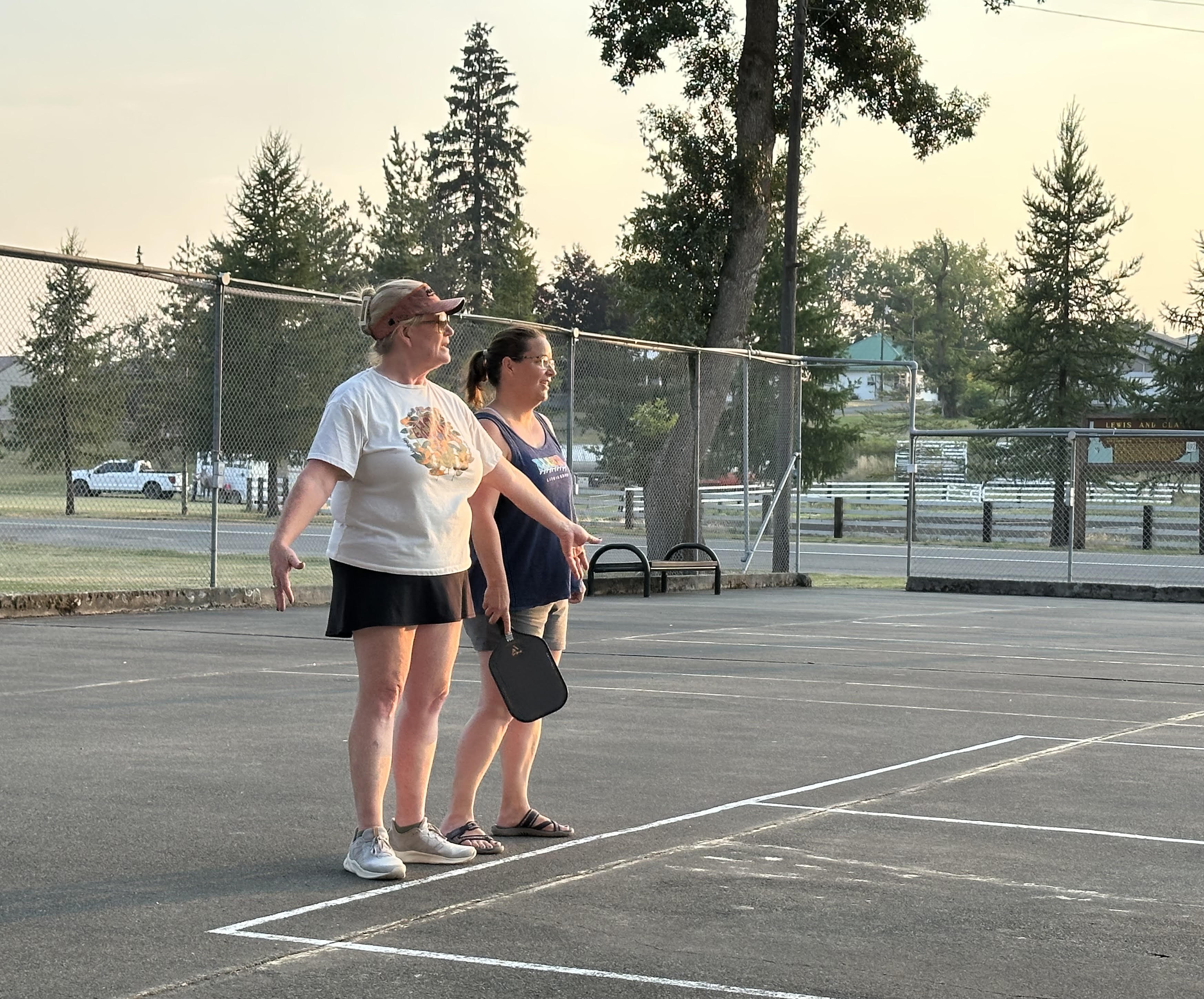 Mayor Kim Ingrams instructs Amanda Currall on how to play pickleball. 